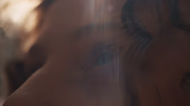 A close-up of a face in warm, soft light.