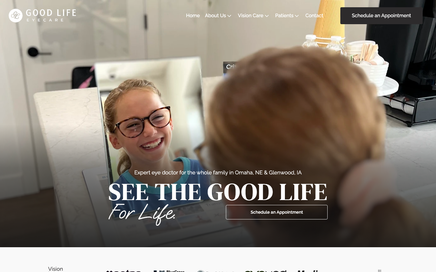 Screenshot of the Good Life Eyecare website hero section with a woman trying on glasses in a mirror