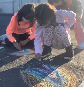 Girls playing with crayons outside