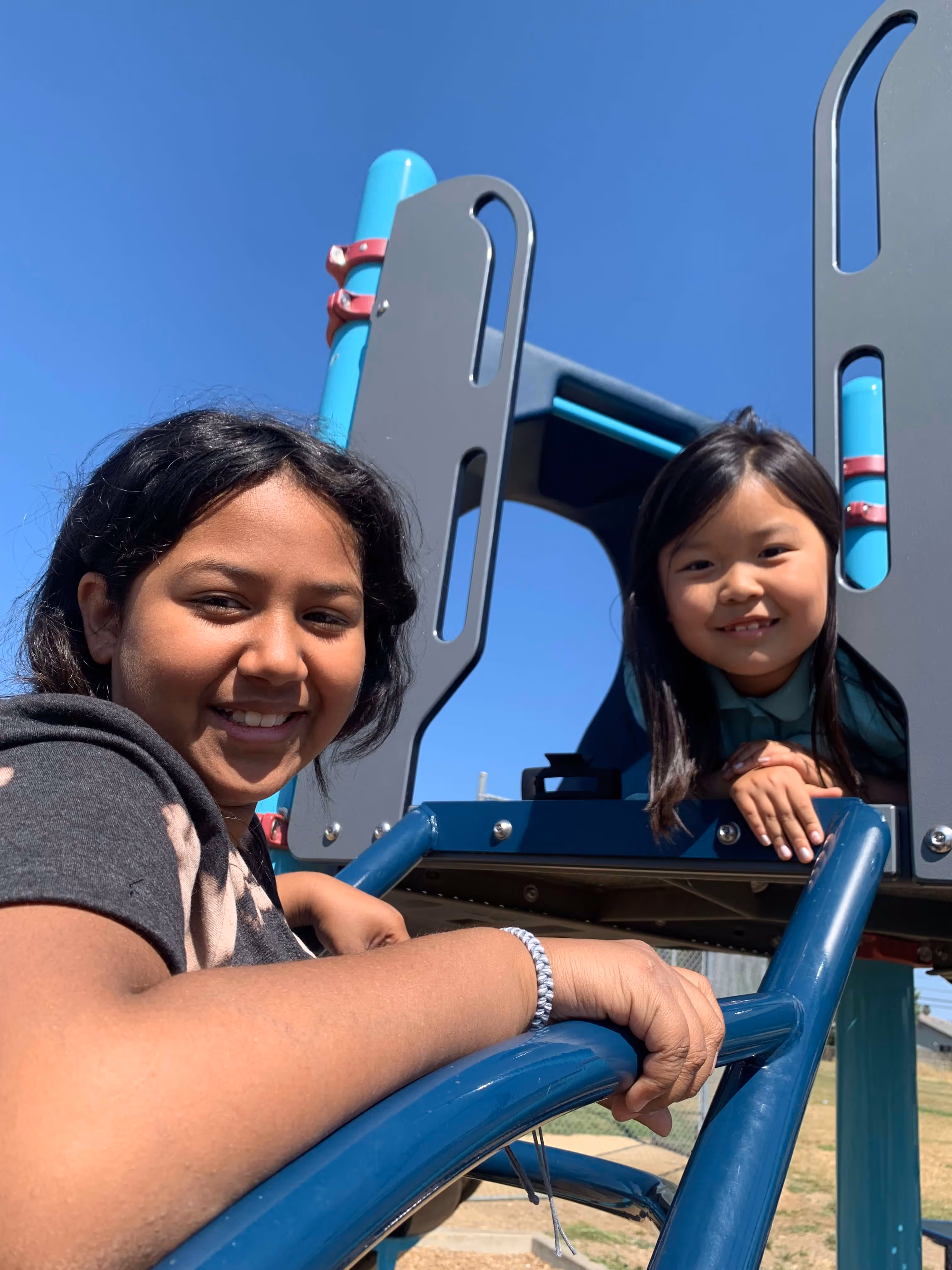 Smiling kids playing on a jungle gym.