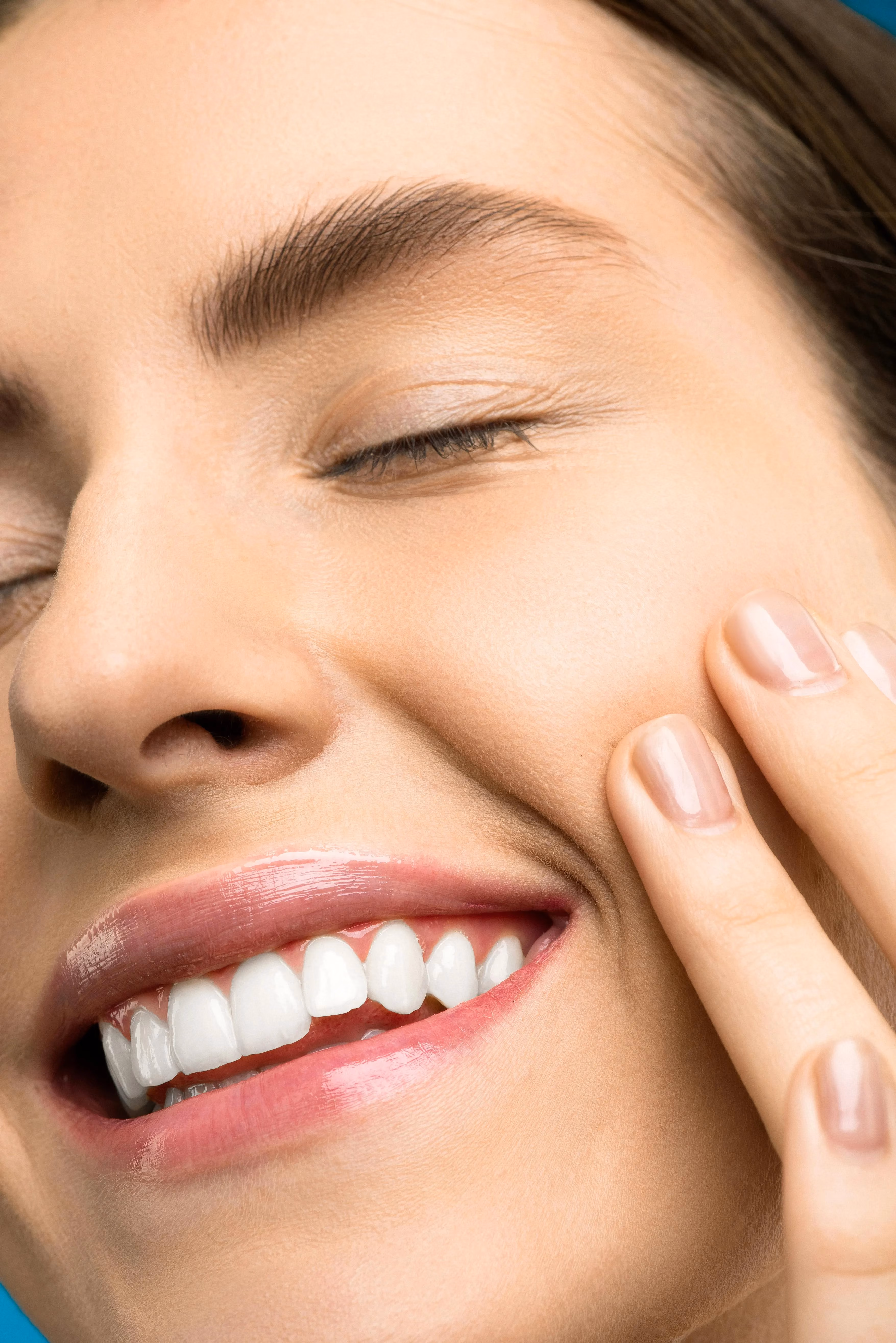 Woman holding cheek due to toothache or sensitivity issue