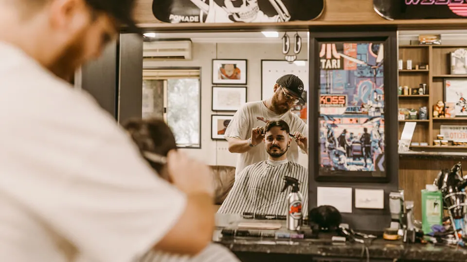 Dan and Nick, Hills barbers at Wiseguys Glenhaven, giving men’s haircuts.