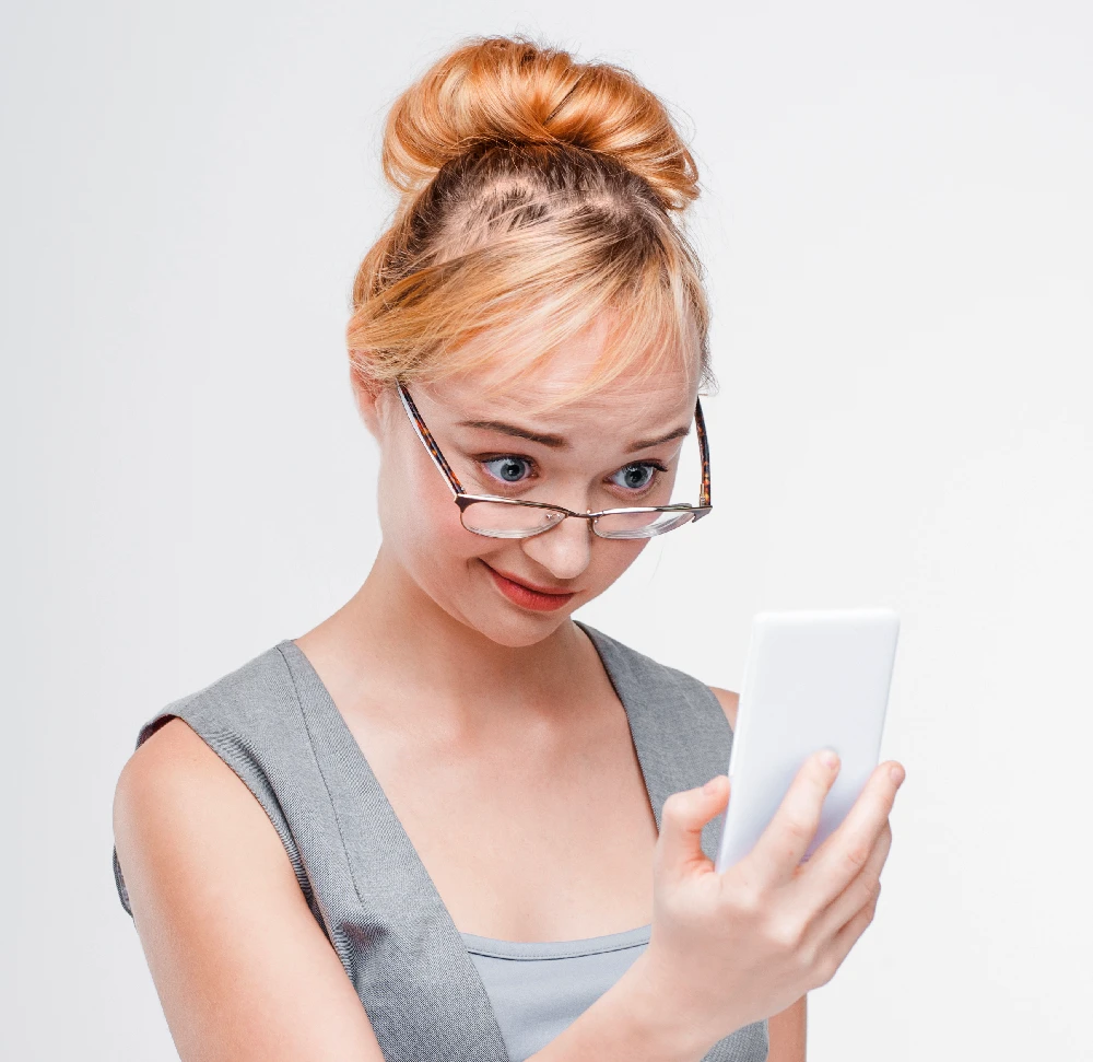 Woman looking disappointed at her phone