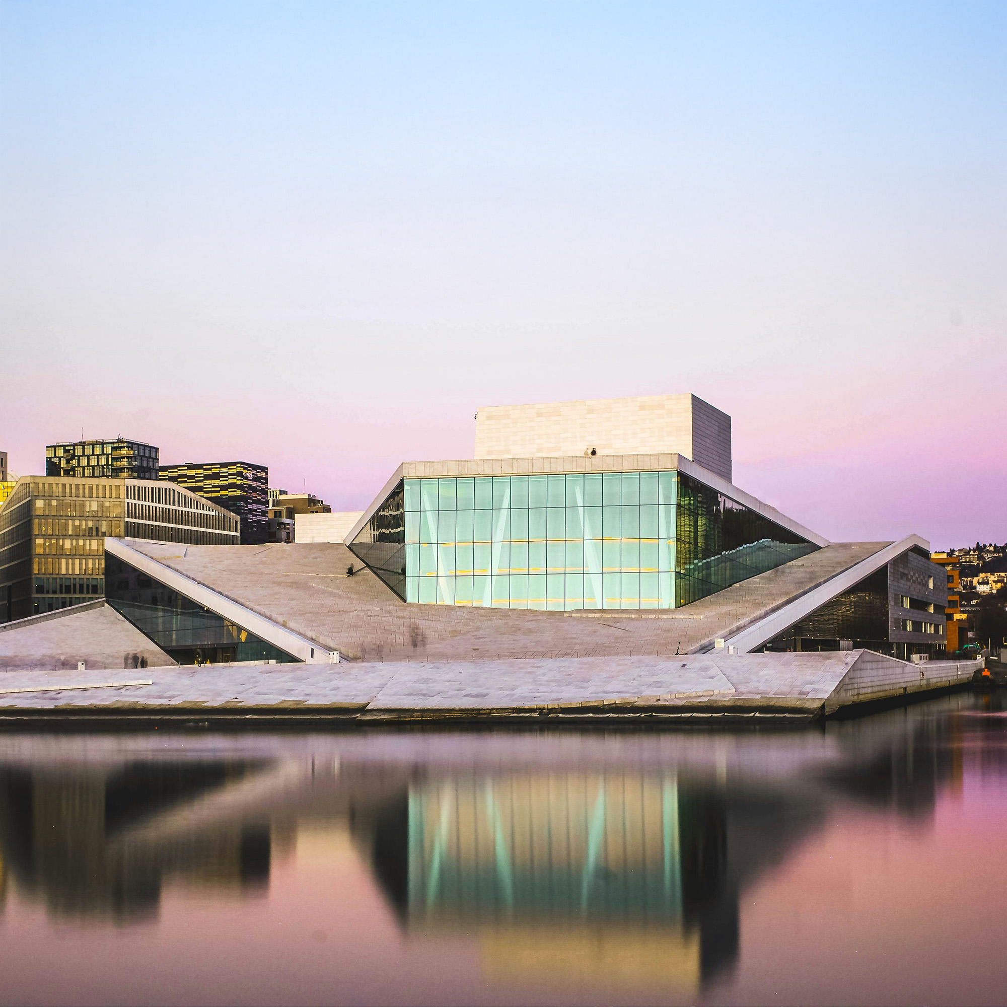 Modern Oslo building reflecting in the water, symbolizing advanced legal and financial expertise in Norway for Clover.Tax.