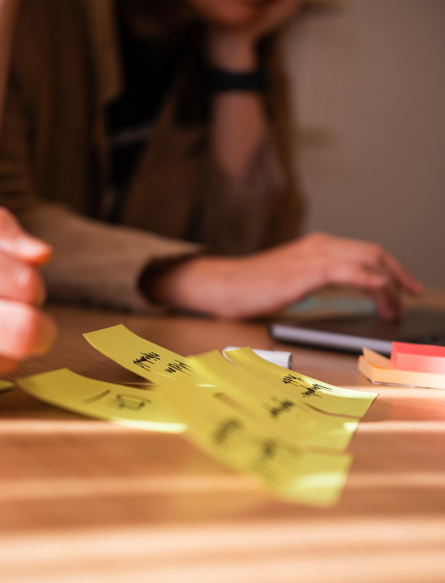 Postit-lappar med handskriven text på ett bord
