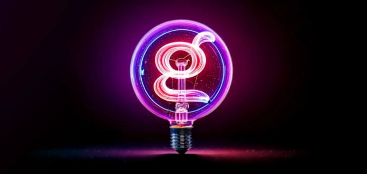 Neon lightbulb glowing in purple and pink, with the letter G shaped filament inside, on a dark background
