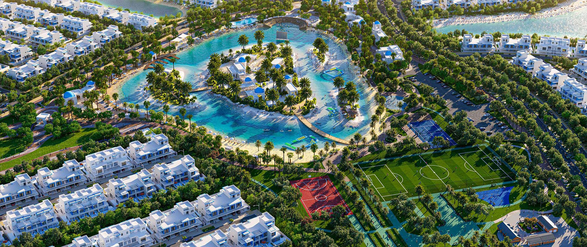 Aerial view of Ibiza at DAMAC Lagoons, showcasing a turquoise lagoon, white villas, palm-lined pathways, and sports facilities including football and basketball courts