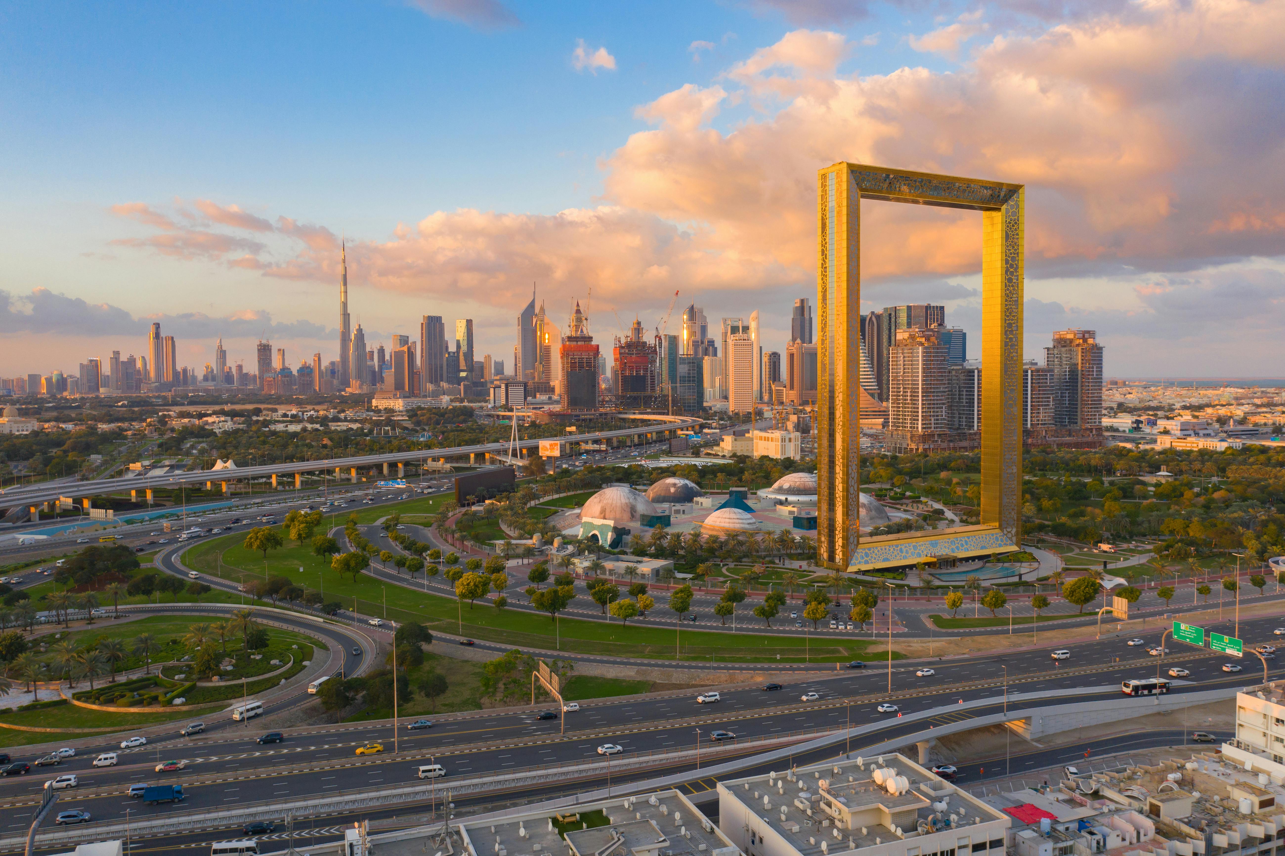 Dubai skyline at sunset with the Burj Khalifa, modern skyscrapers, highways, and the Dubai Frame, linking to the blog 'Dubai’s Economic Secret: Why This City Is Bubble-Proof