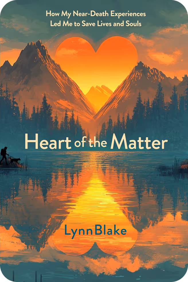 Book cover with mountains and orange sunset forming a heart shape reflected in a lake, titled 'Heart of the Matter' by Lynn Blake.