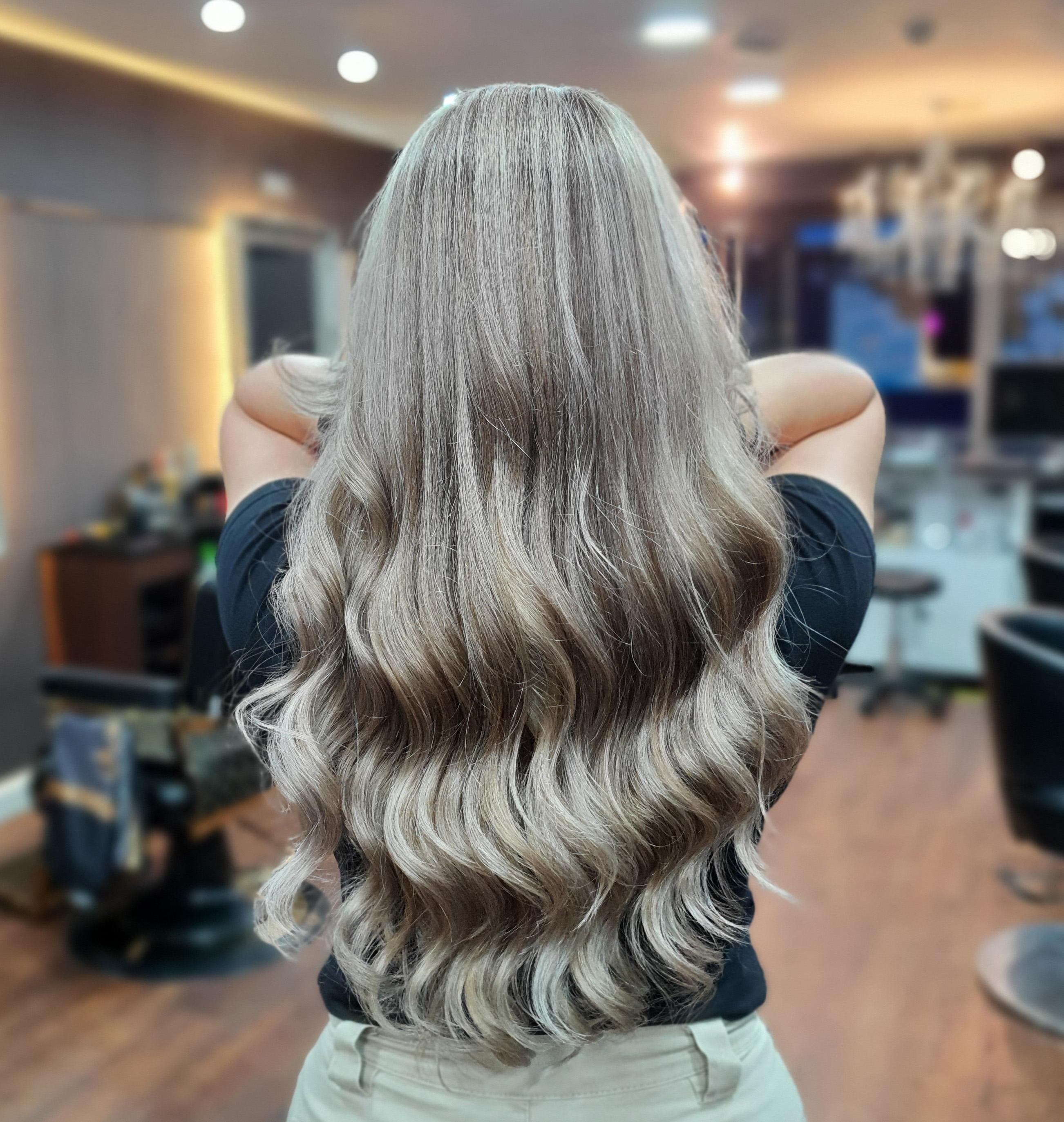 Long, wavy silver and gray hair styled in a hair salon