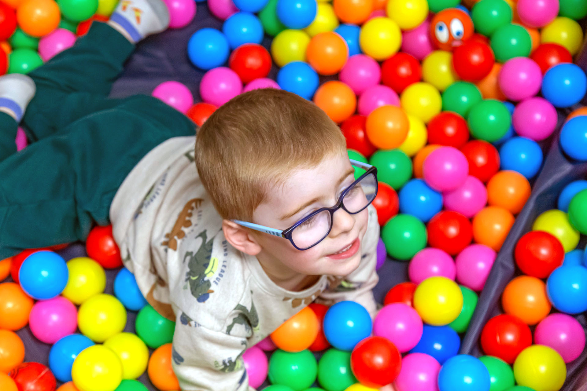 A joyful, candid moment of a child engaging in sensory or creative play at Advanced Therapy Clinic.
