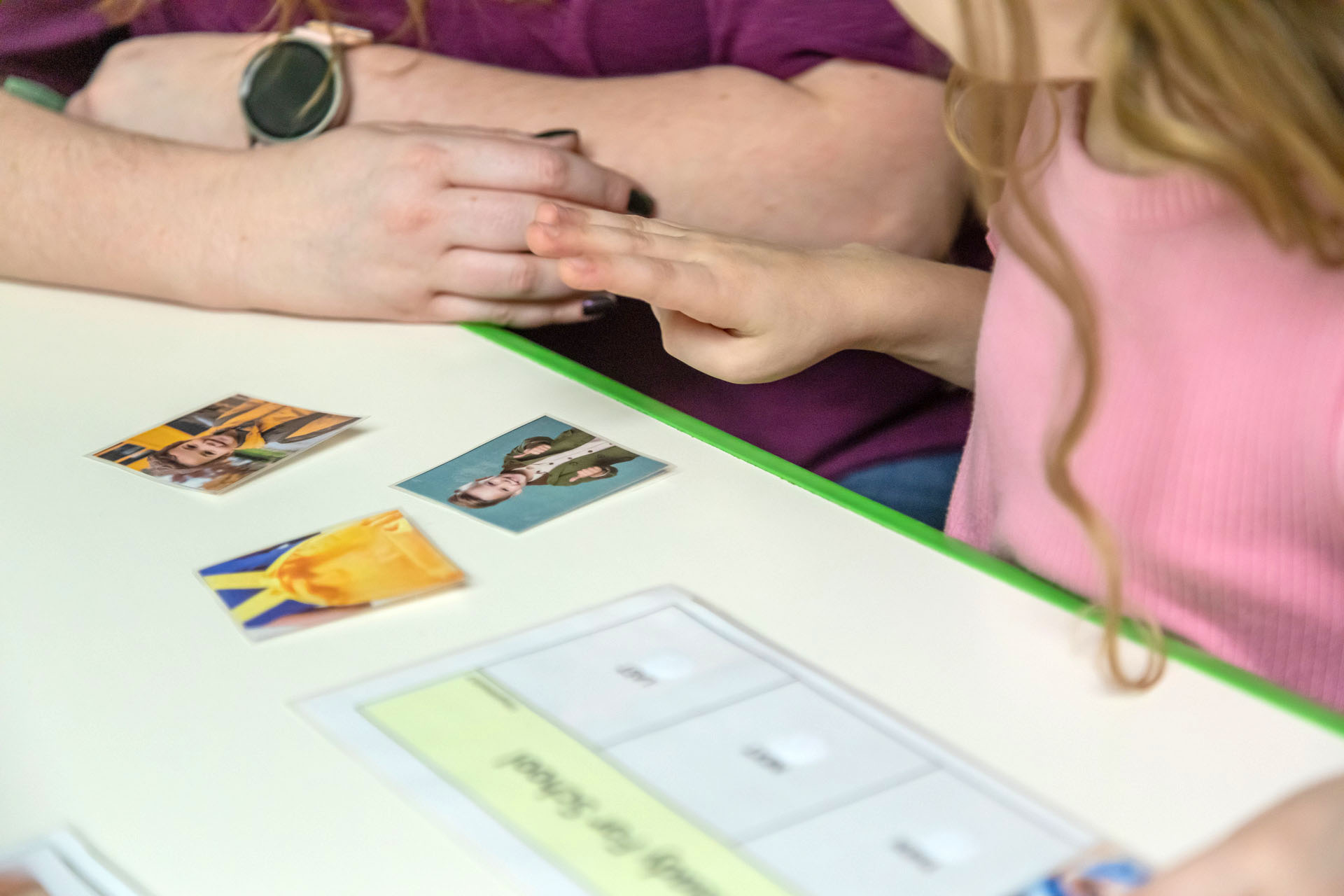 A speech‑language pathologist interacting with a child using picture cards