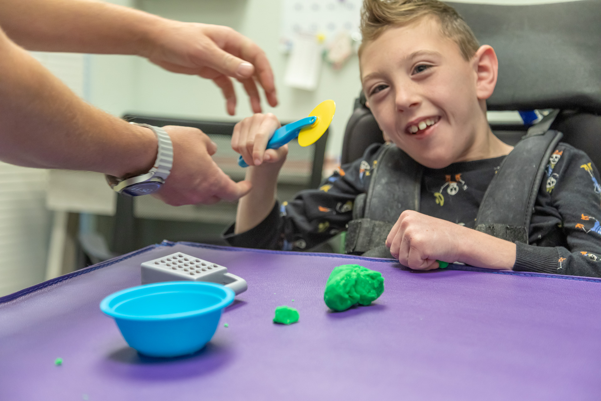 Child practicing hands-on motor activities with therapist support, building strength, coordination, and confidence during pediatric physical therapy.