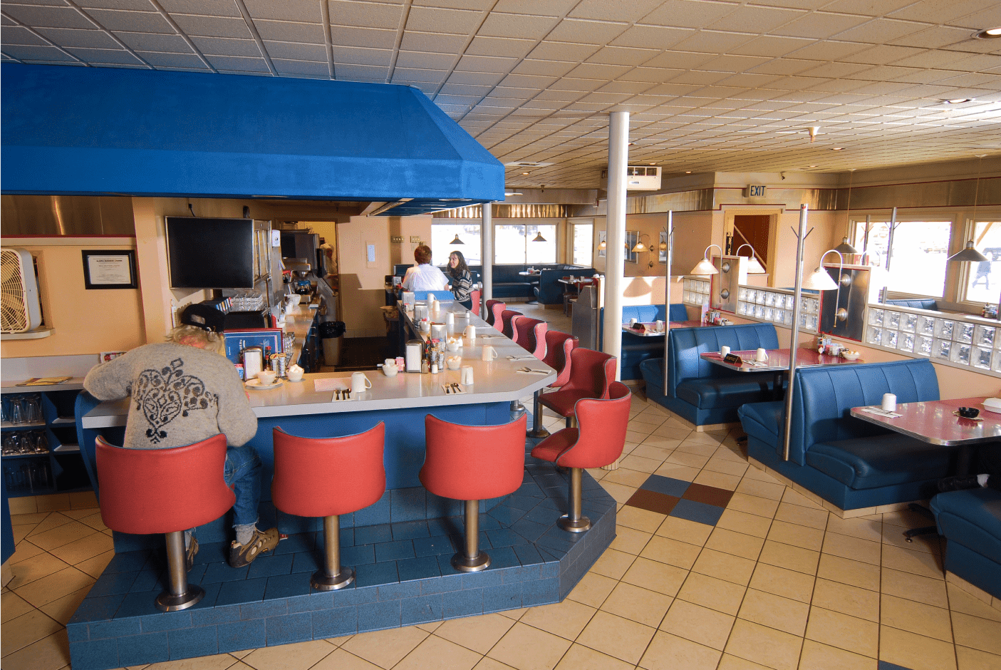 Comfortable booth seating at The Landing's Diner full of customers and home-style food.