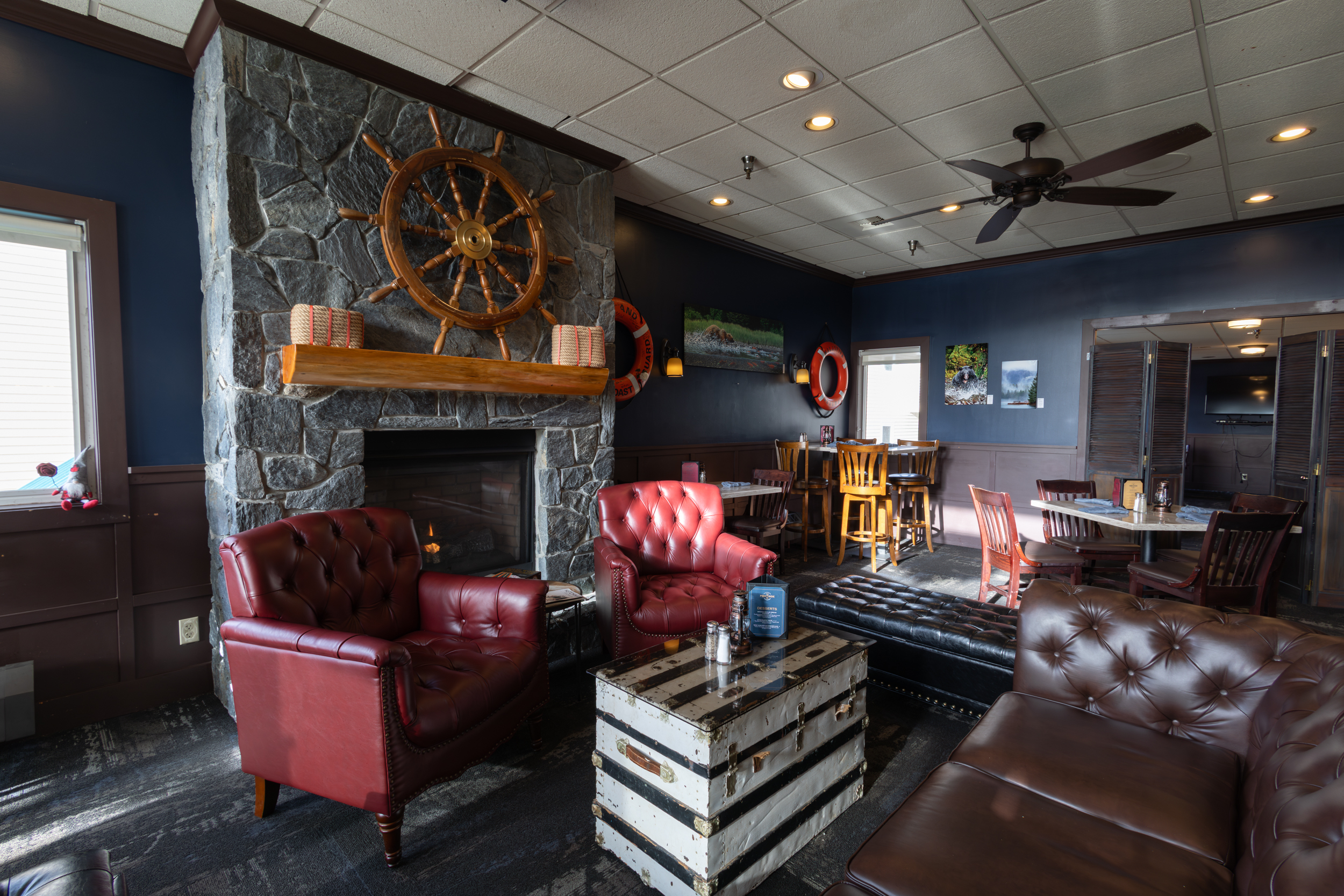 Various sections of Jeramiah's Pub, complete with bar seating, window booths, family tables, Alaskan memorobelia, and a view of the kitchen.