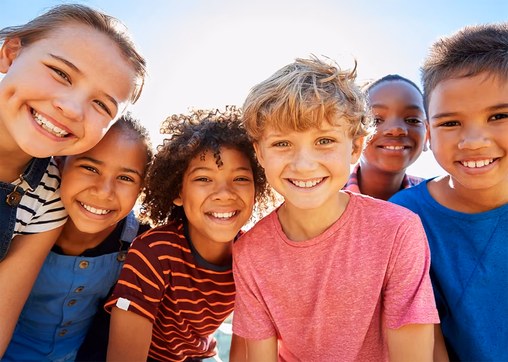 Group of multi-cultural kids outside at park in San Francisco smiling