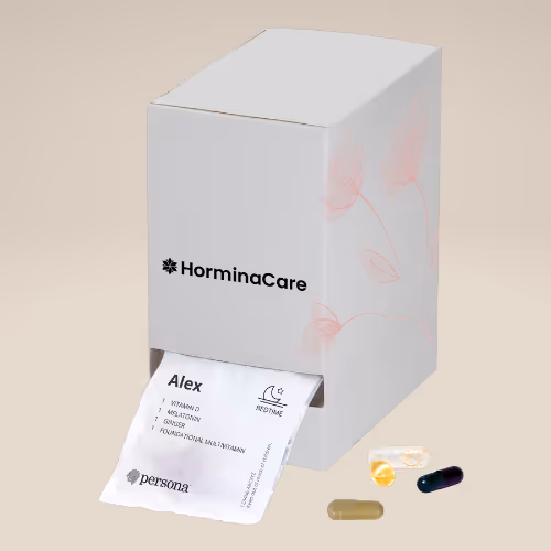 White HorminaCare supplement box with light pink floral design, dispensing a personalized vitamin list for Alex, alongside four assorted capsules and soft gels.