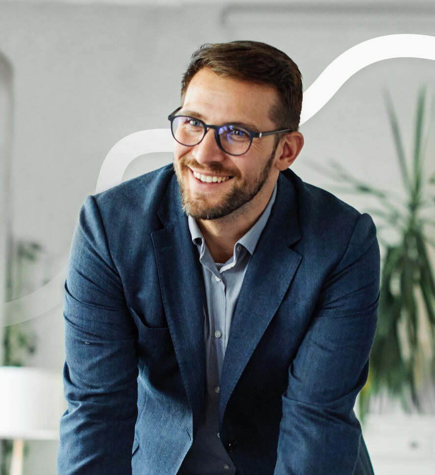 Man stützt auf Bürotisch und Lacht