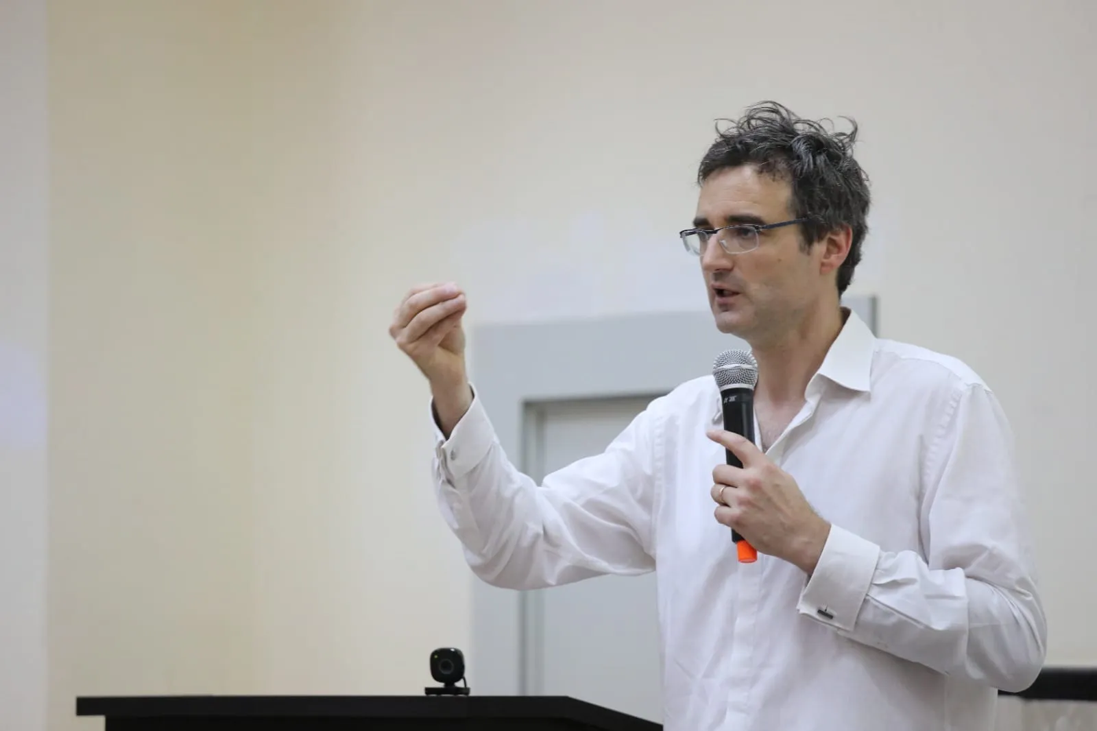 A photography of Thomas Deneux, Founder or Learning Robots, hosting a conference.