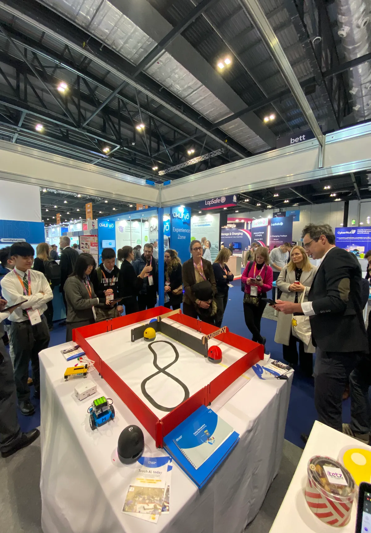 Fotografie des Learning Robots-Stands auf der Bett Show mit Besuchern, die einer Demonstration beiwohnen