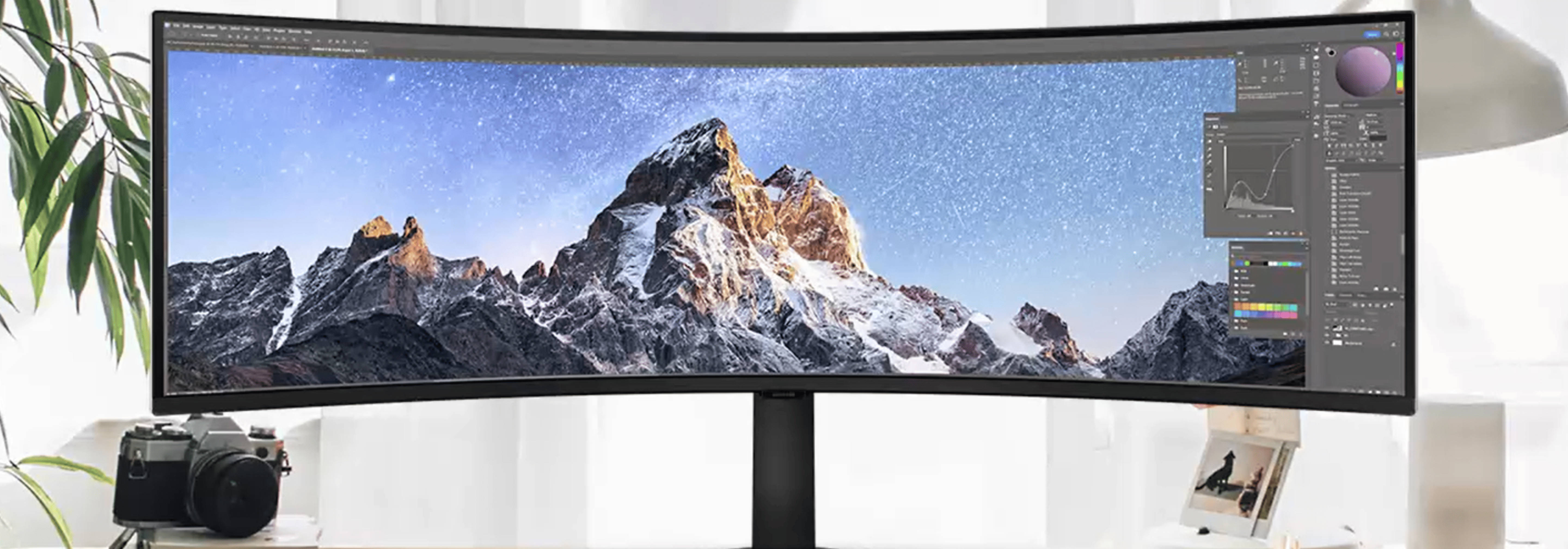 Écran incurvé ultra-large affichant un logiciel de retouche photo avec une image de montagnes enneigées.