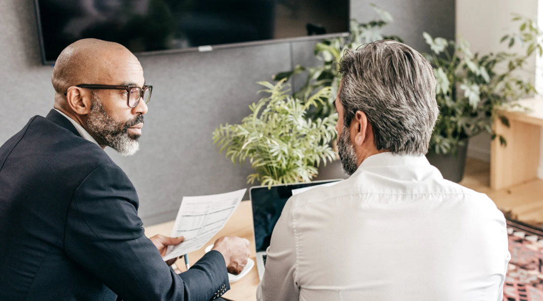 Deux professionnels échangeant lors d'un audit informatique en entreprise.