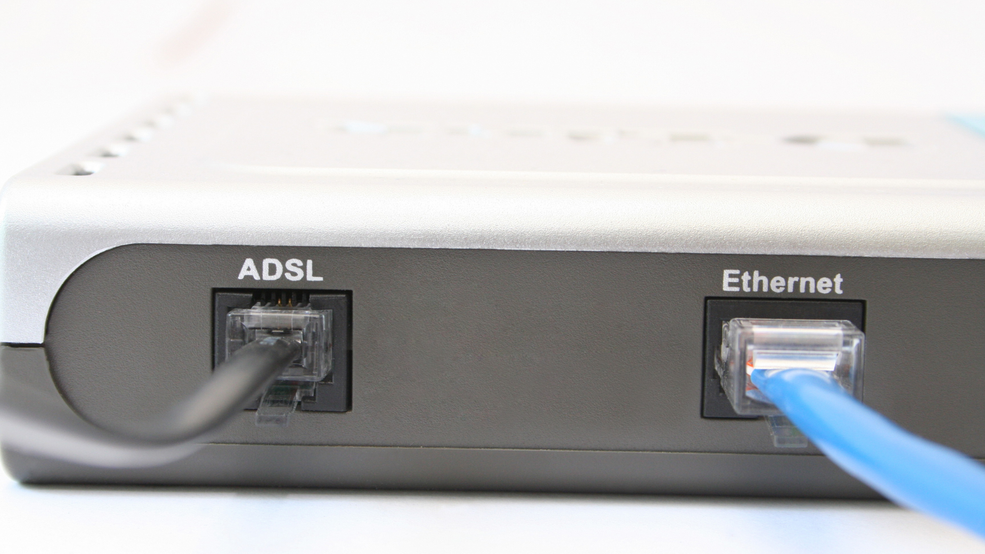 Gros plan sur un routeur avec des câbles ADSL et Ethernet connectés.