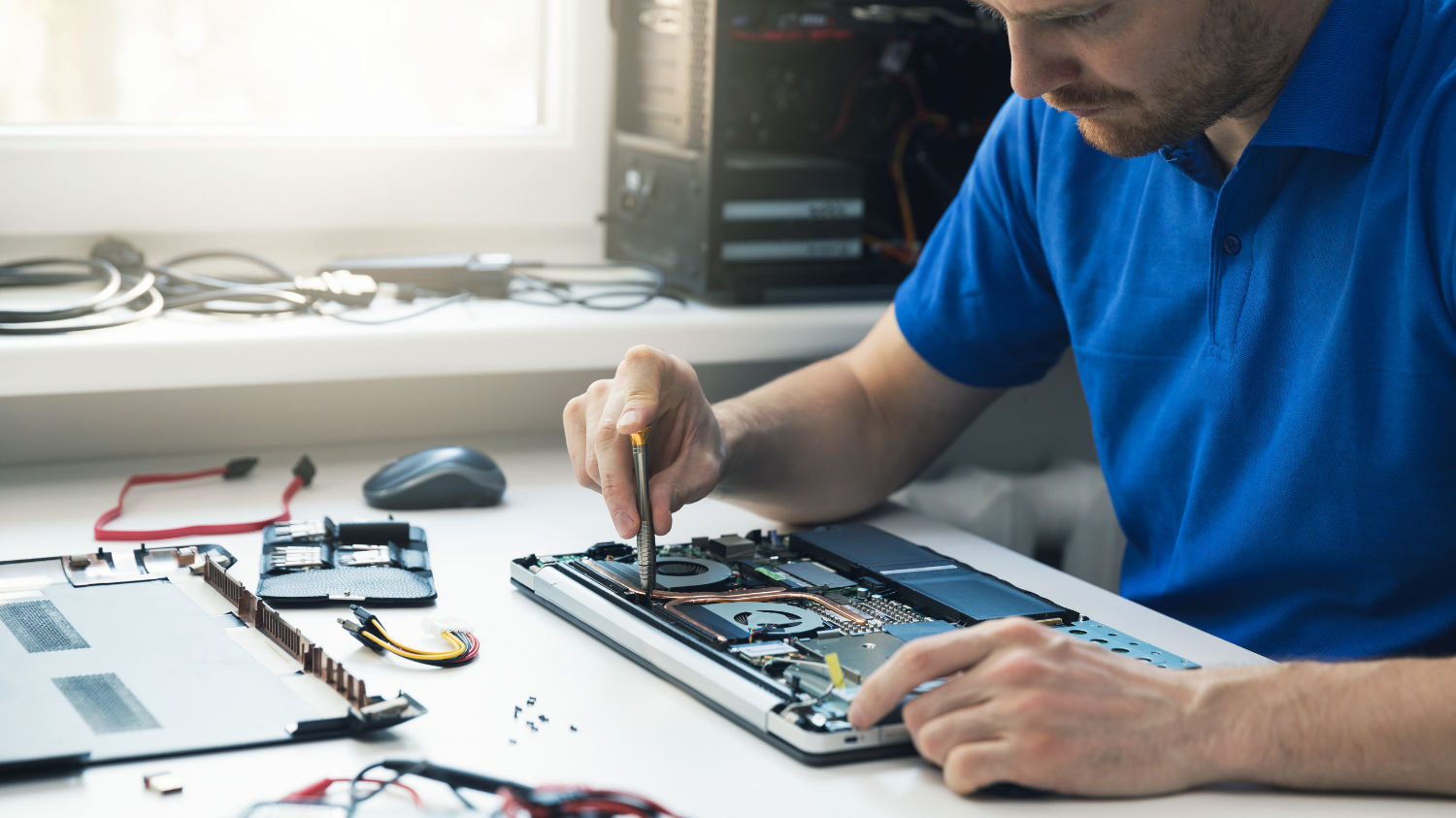 Technicien réparant les composants internes d'un ordinateur portable.
