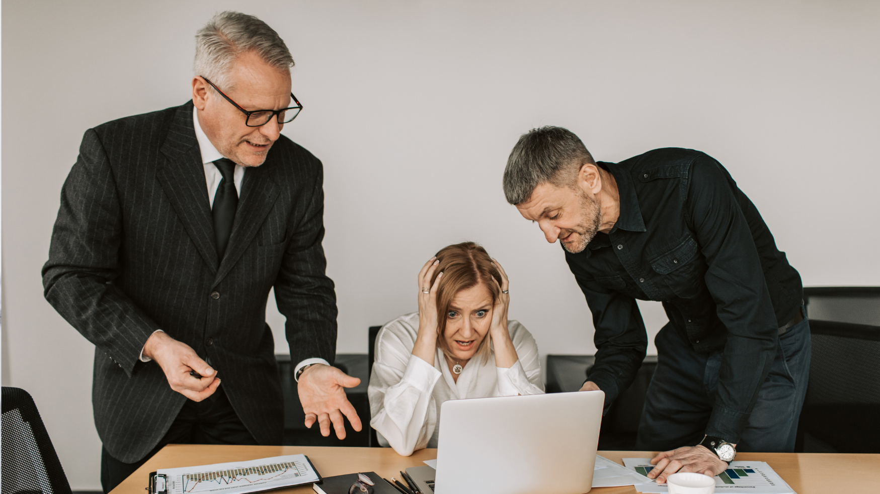 Collaborateurs réagissant à une panne informatique devant un ordinateur portable.