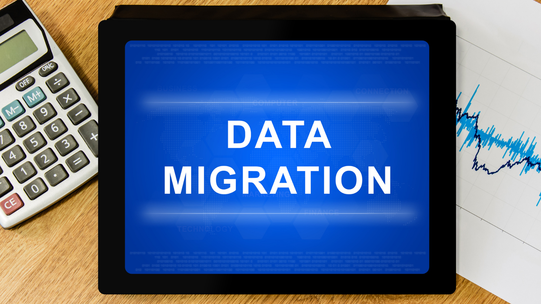 Tablette affichant le message « Data Migration » à côté d'une calculatrice et de graphiques.