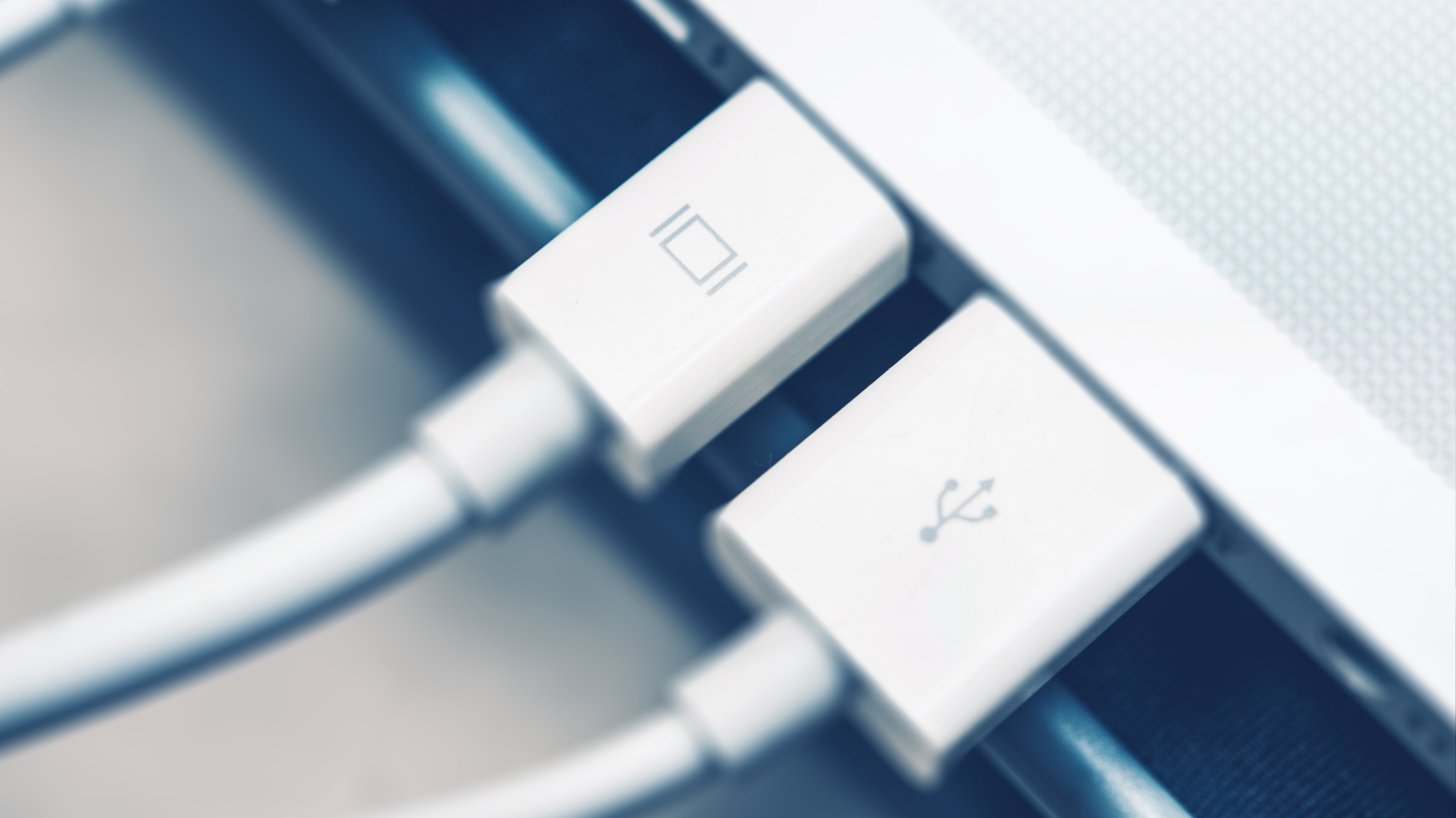 Gros plan sur des câbles USB et vidéo connectés à un ordinateur portable professionnel.