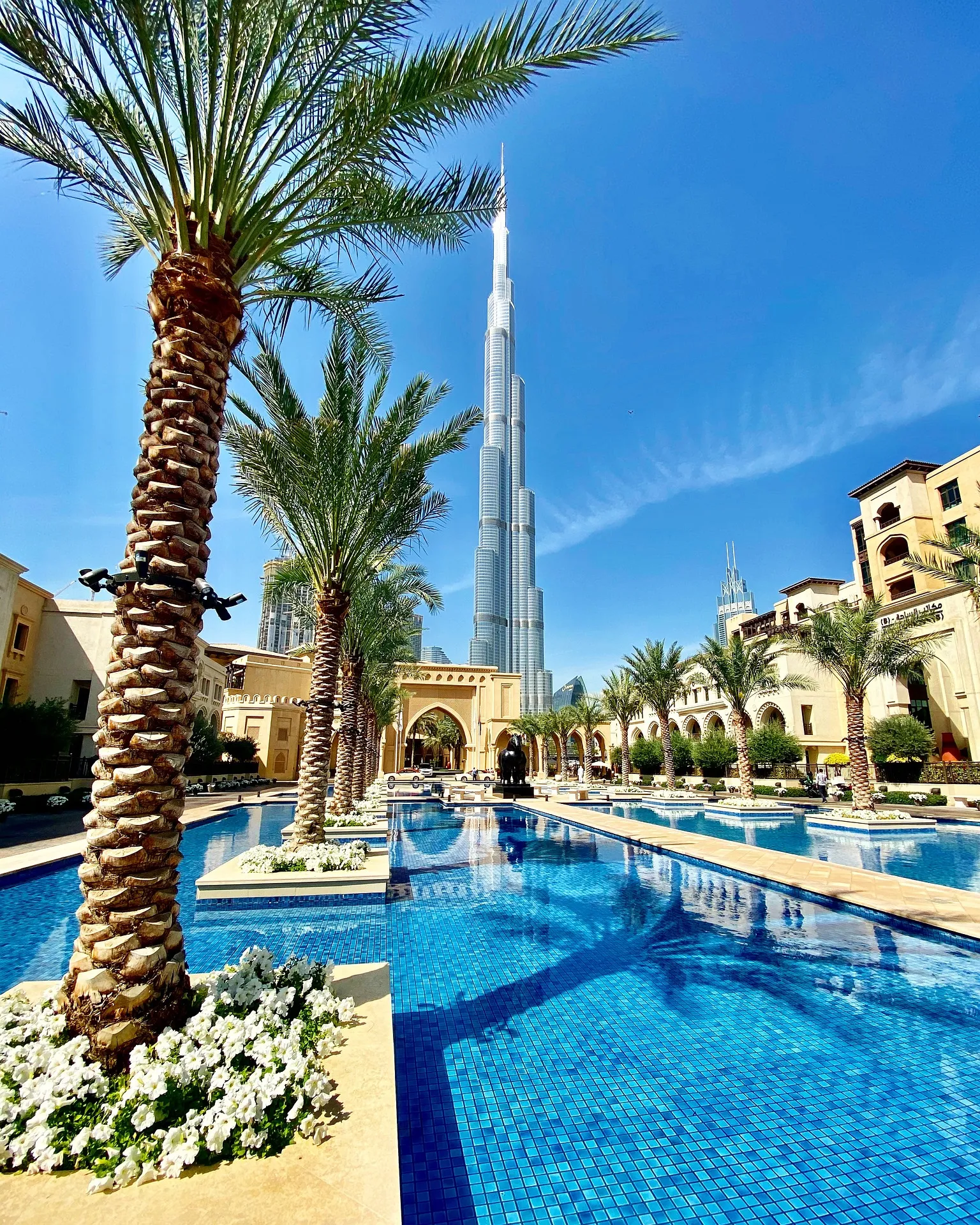 Burj Khalifa hinter Palmen und einem Pool in Downtown Dubai