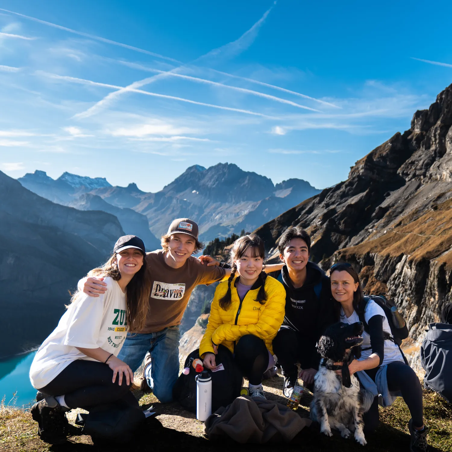 An image of a group of students smiling and posing in front of a view of mountains.