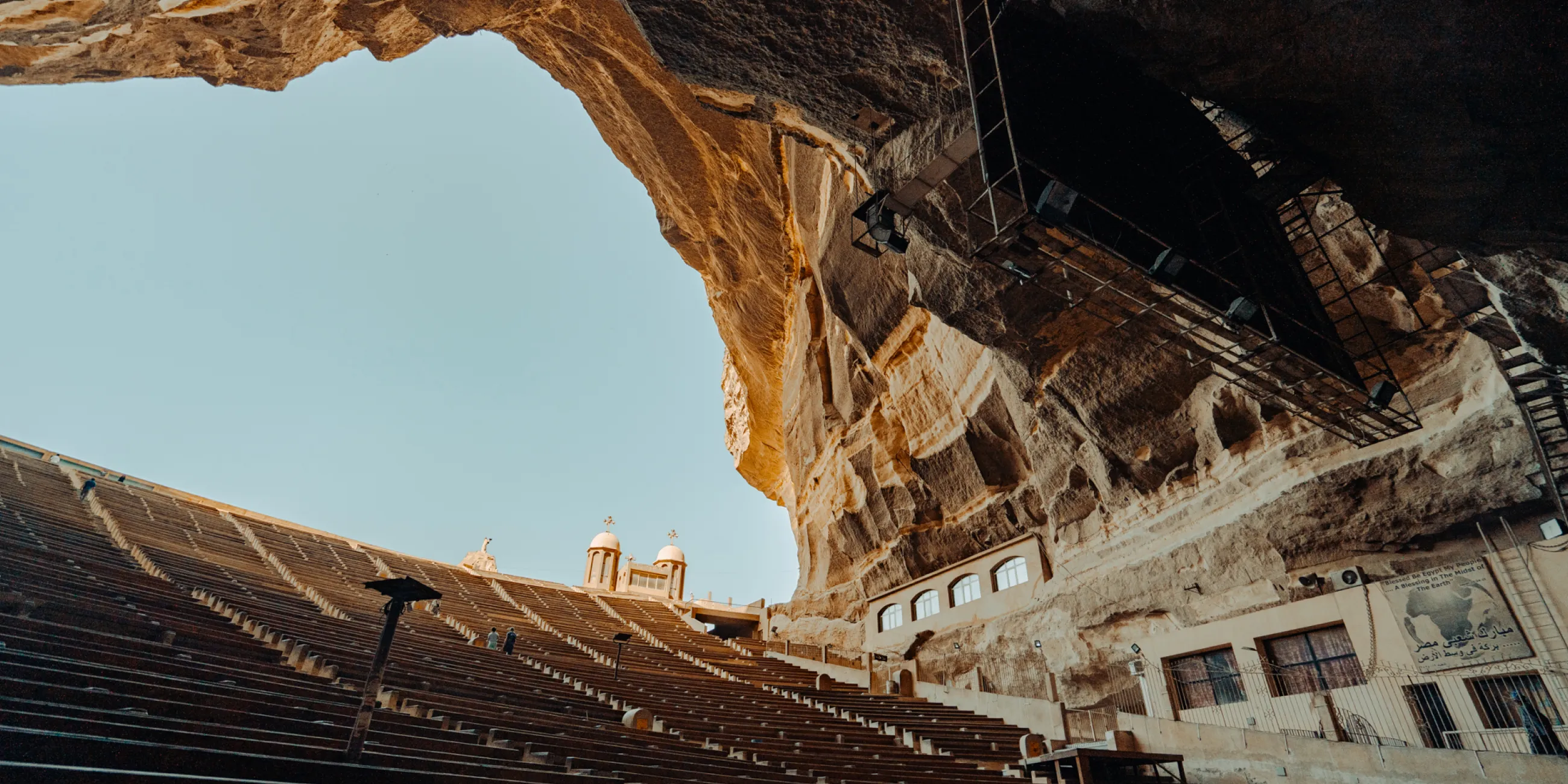 A cave within a rocky mountain containing a building and stairs from the Mediterranean DTS at YWAM Lausanne.