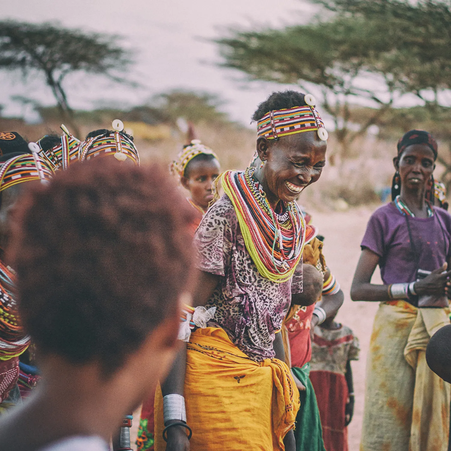 A group of local African individuals smiling and taking part in an Outreach programme.