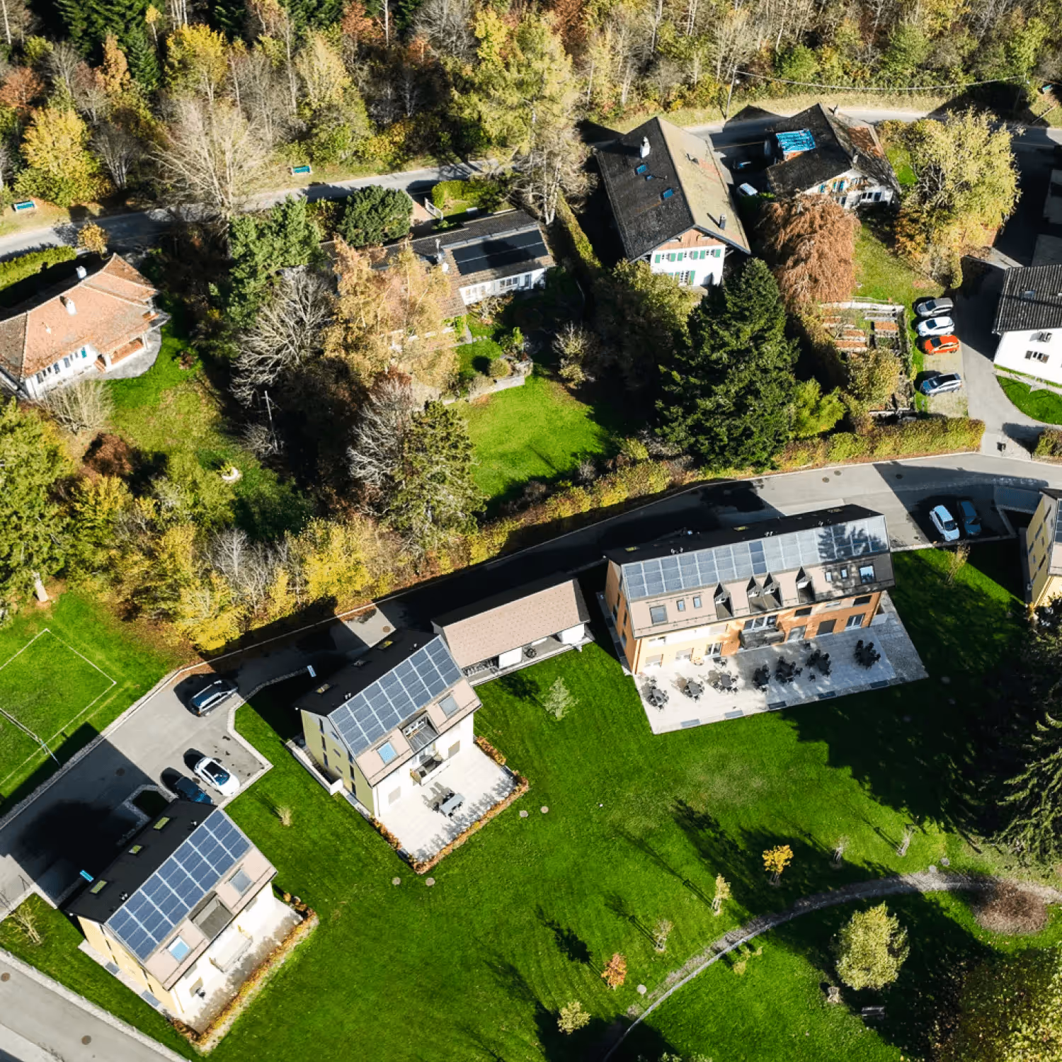 Overview of DTS campus buildings at YWAM Lausanne amongst green grass and trees.
