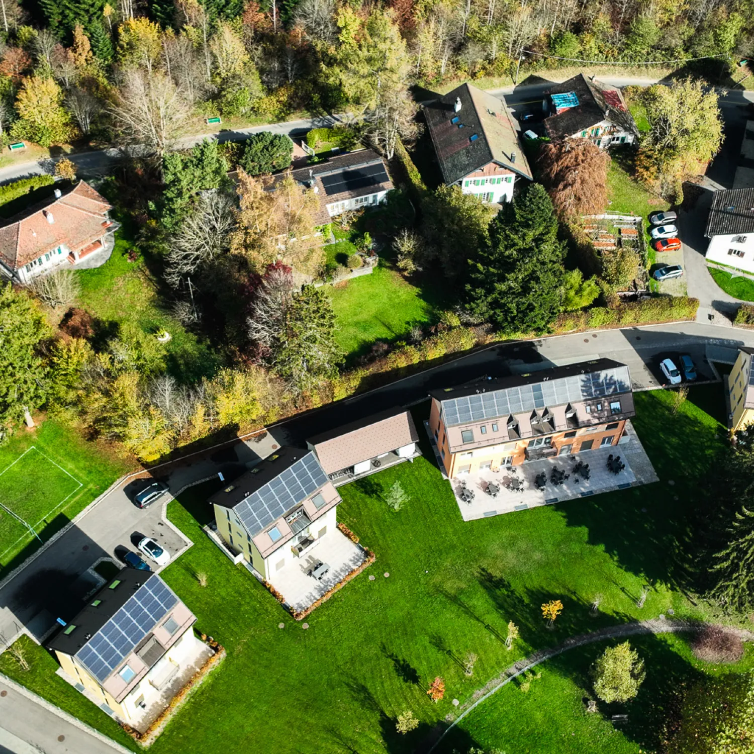 Overview of DTS campus buildings at YWAM Lausanne amongst green grass and trees.