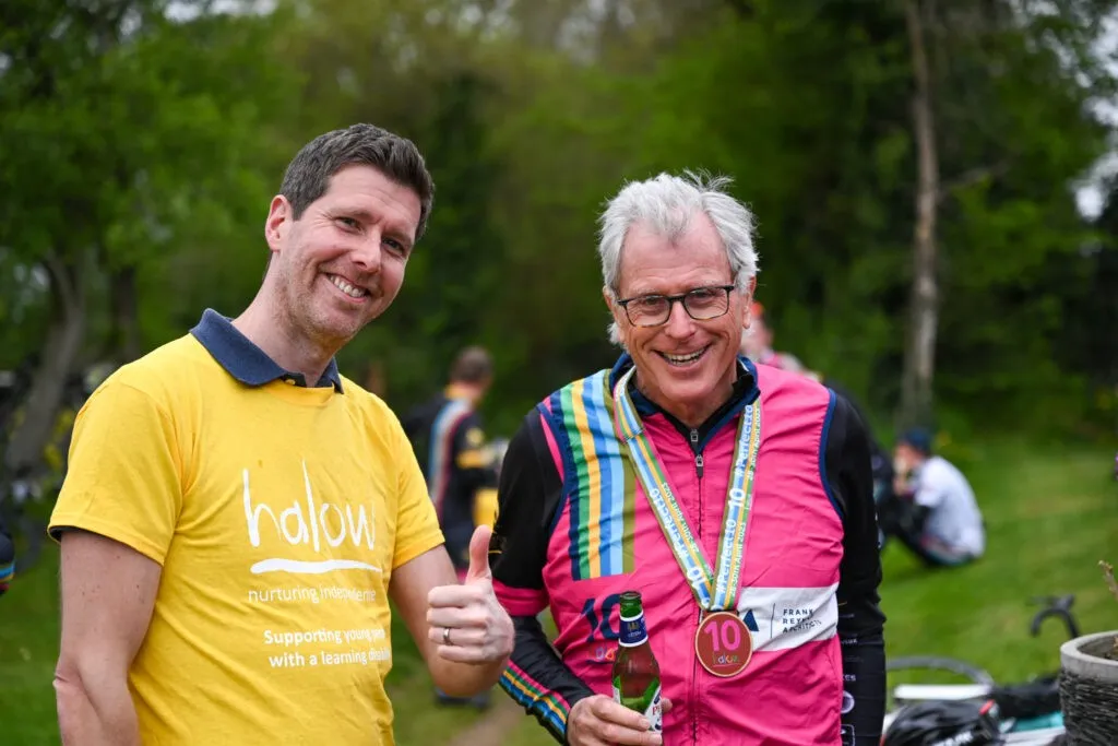 Two men smiling and giving a thumbs up