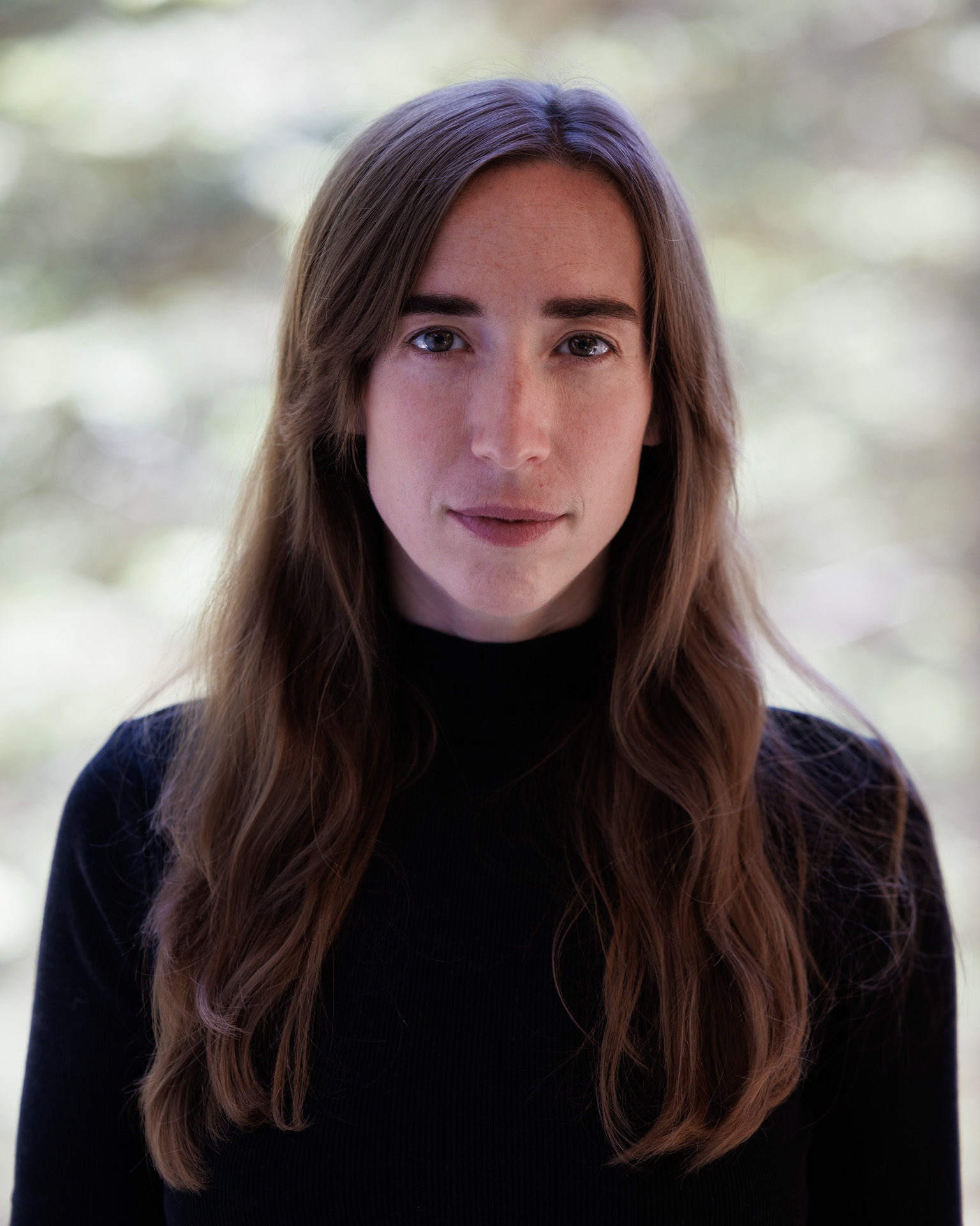 A photo of Emily Neigel outside in a black turtleneck sweater