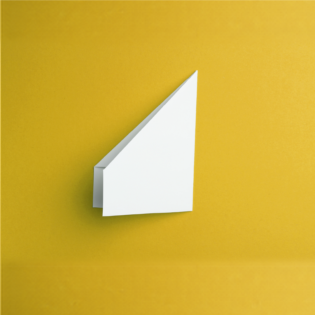 A white paper fold at the moment it gains direction on a yellow surface