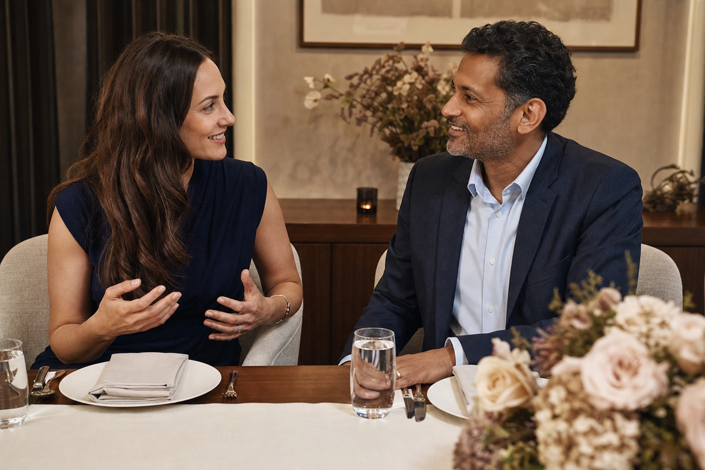 Two dinner guests introduce themselves before a meal.