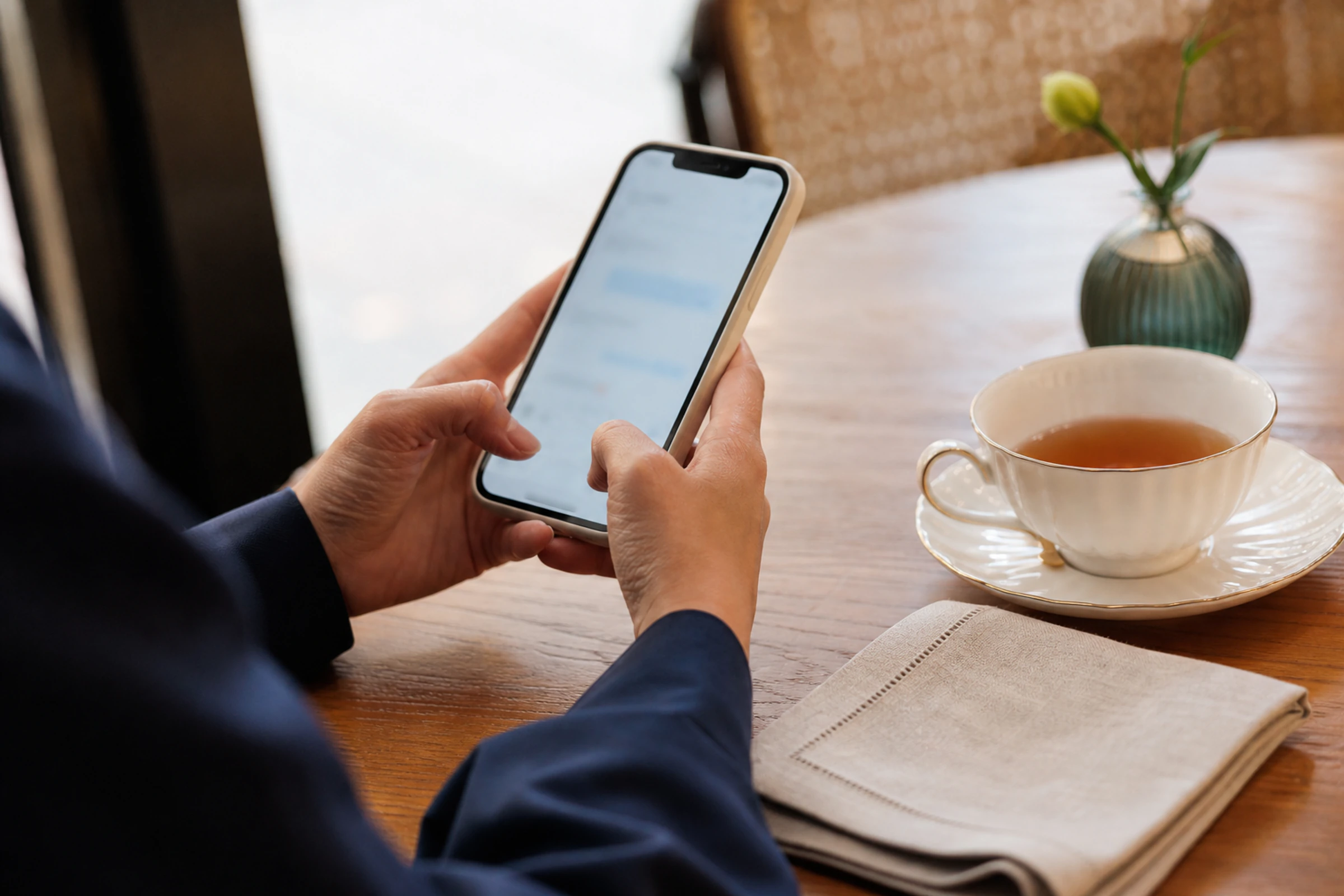 A person sends a thank-you message from a quiet café table