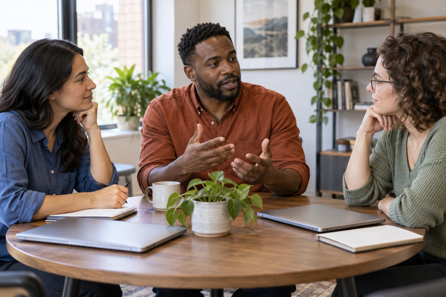 Three colleagues clarify responsibilities around an office table.