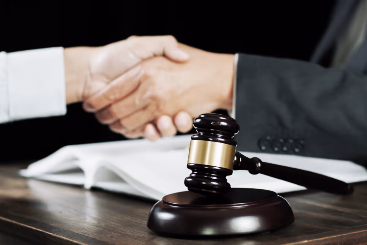 Two people shaking hands in a law office.