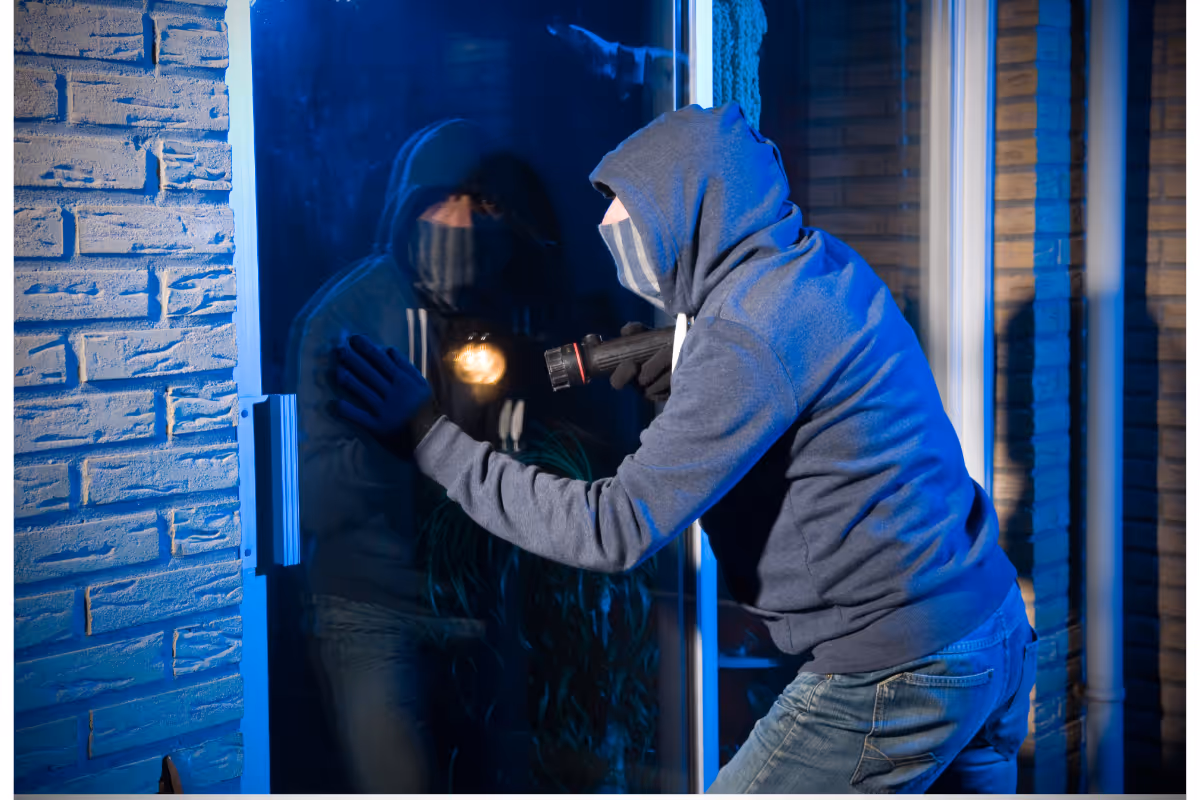 A burglar trying to break into a house.