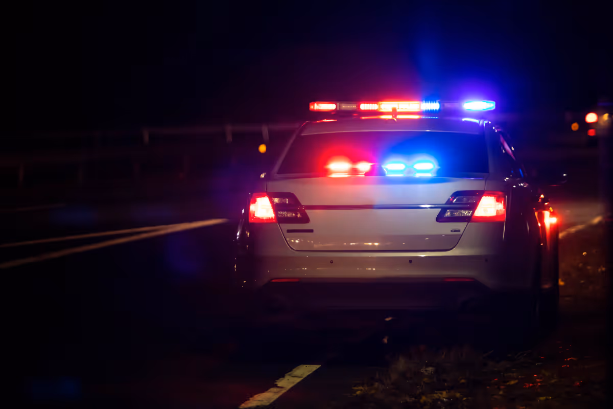 A police vehicle on the side of a road at night.