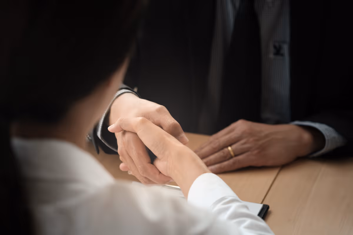 Two people shaking hands in an office.