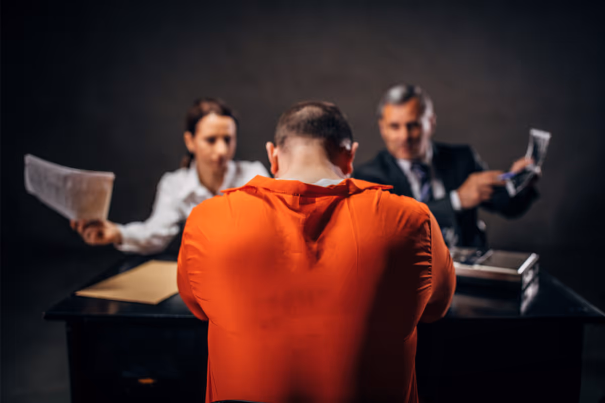 A prisoner in a questioning room with two police detectives.