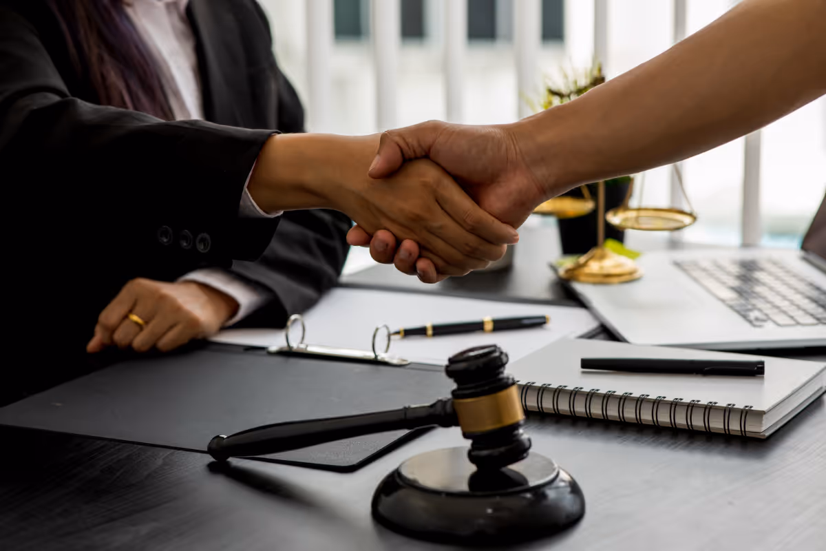 Two people shaking hands in an office.