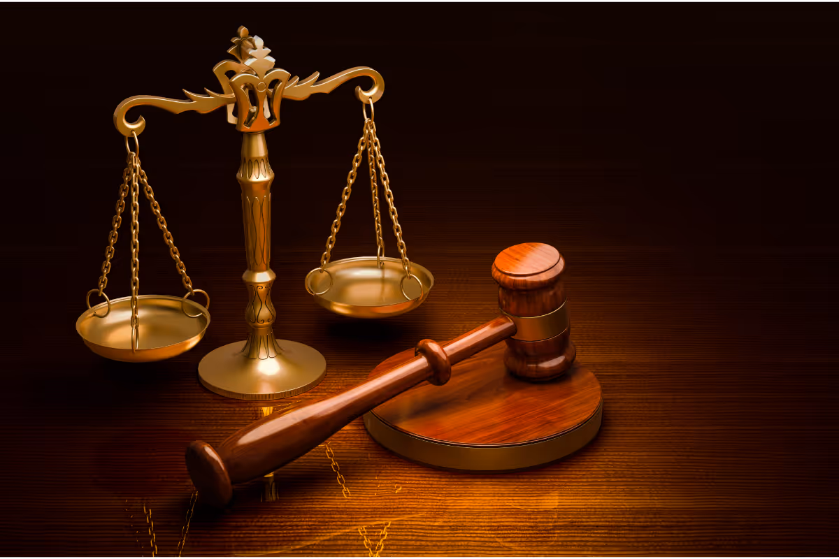 An image of a gavel and the scales of justice on a table.